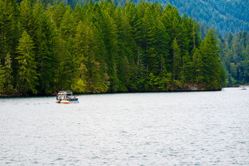 Fototapeta na wymiar wonderful rest with boat ride on the picturesque mountain Merwin Lake with an evergreen forest