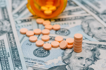 money and pills in pill bottle and stethoscope on table medical expense concept
