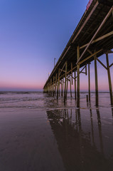 Pier reflecting at sunset in Carolina Beach, North Carolina, USA