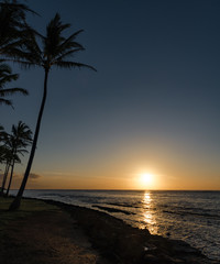 Fototapeta na wymiar sun rising & reflecting on the ocean in Kauai, Hawaii, USA