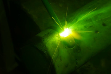 Metal pipe during welding. Sparks and scale