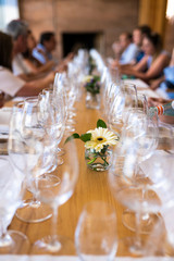 Perspective view of champagne and wine glasses going to infinity on a friends Christmas lunch at a Chilean vineyard in Casablanca. Luxury and elegant with an awe row line of glasses with a nice flower