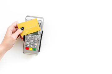 Pay by payment terminal. Paypass  technology. Woman's hand hold credit card, bring card to terminal  on white background top view copy space