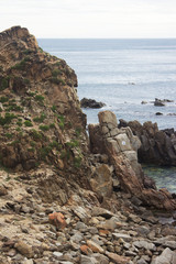Fototapeta na wymiar Mountain and pebble on sea shore line
