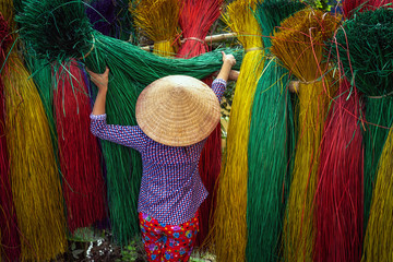 Back side of Vietnamese female craftsman drying traditional vietnam mats in the old traditional...