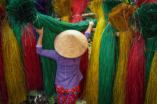 Back side of Vietnamese female craftsman drying traditional vietnam mats in the old traditional village at dinh yen, dong thap, vietnam, tradition artist concept