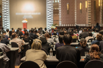 Rear view of Audience wearing and listening Speakers via Interpreter Headset on the stage in the...