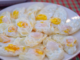 Fried eggs on the white dish.