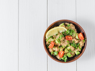 Salad of amaranth seeds, avocado, tomatoes, lemon and parsley with olive oil on a table. The view from the top.