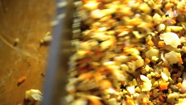 Cutting a selection of healthy nutritious vegetables on wooden chopping board with Balinese Blakas in Indonesia