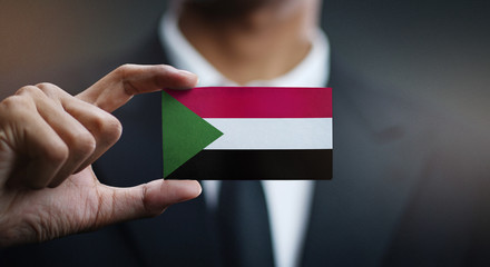 Businessman Holding Card of Sudan Flag