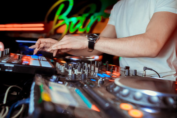 Dj mixes the track in the nightclub at party