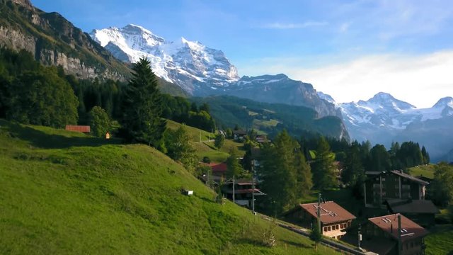 Switzerland aerial rise revealing shot, Wengen chalets and snow capped mountain.