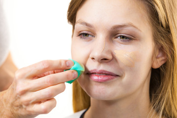 Woman applying foundation with sponge