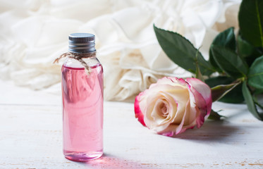 perfumed rose water in a bottle on a wooden table