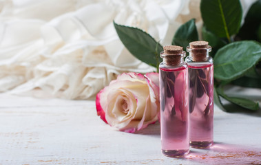 perfumed rose water in a bottle on a wooden table