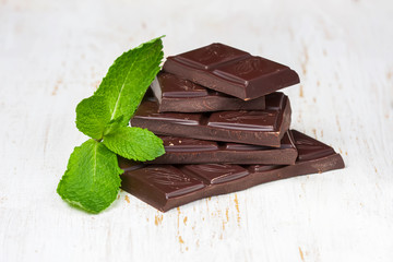 Dark chocolate  with fresh mint on a white background wooden