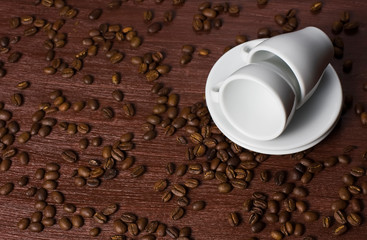 White coffee cup on a dark background with coffee beans