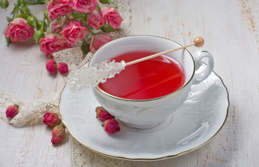 Cup of tea with dried rose buds and fresh roses
