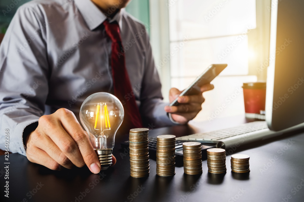 Poster business man hand holding lightbulb with using smartphone and calculator to calculate and money stac