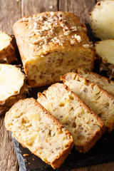 Delicious dessert sliced pineapple bread with walnuts close-up on the table. vertical