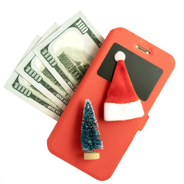 Mobile phone in a red case, a souvenir Christmas tree and a Santa Claus hat and three hundred US dollars on a white background. Square frame Isolated Copy space.