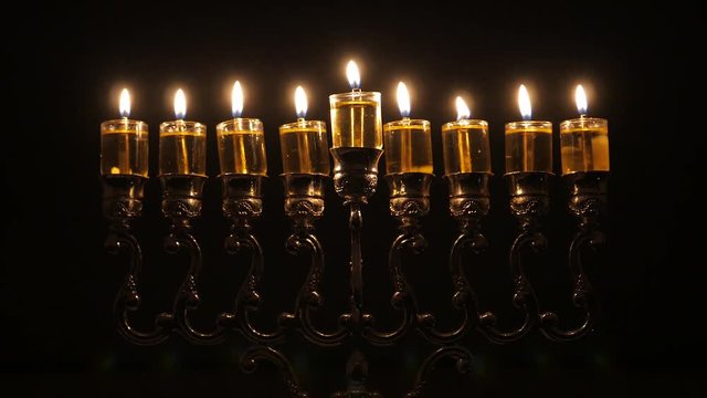 Loop video. The 8th day of the Jewish holiday of Hanukkah. Beautiful Lit Hanukkah Menorah On Dark Background