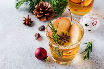 Traditional Christmas apple punch with cinnamon, anise and sprigs of rosemary on light background. Selective fоcus. Top view.