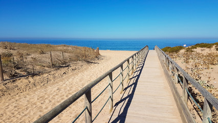 Wooden path on sand to sea. Vacation and rest on a beach concept