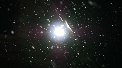 snow falls slowly in night winter. lantern shines through the snow. slow motion - Powered by Adobe