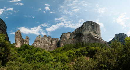 Rocks in Meteora region with blue sky and white clouds - famous place with monasteries on tops, UNESCO World Heritage, Greece. Panoramic photo.