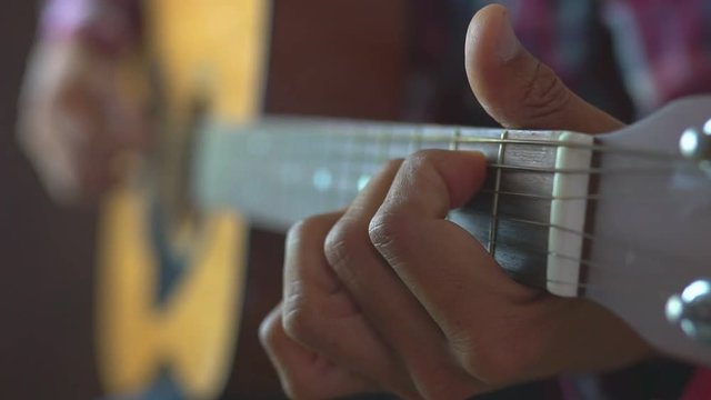 close up man playing guitar