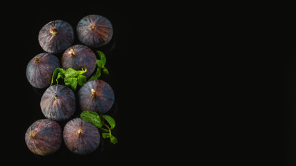Fresh figs with mint leaves on a black background. copy text. Flat lay