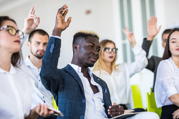 Group of business people raise hands up to agree with speaker in the meeting room seminar. Business...