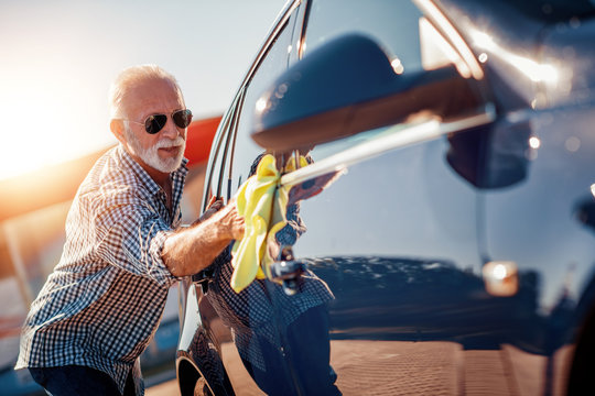 Senior Man Cleaning His Car Outdoors