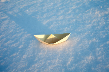 beige paper boat in the snow