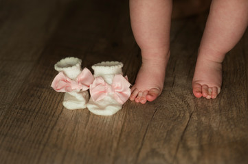 legs of newborn baby close up on isolated wooden background