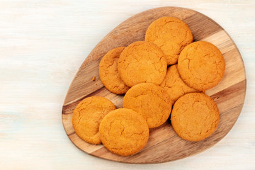 Gingersnaps on a wooden tray, shot from above with copy space
