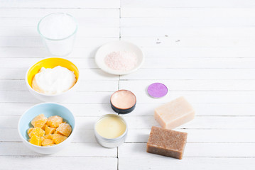 bath salts, beeswax , makeup base, powder compact, soaps and cosmetic creams on white wooden background