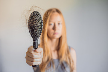 Hair loss in women concept. A lot of lost hair on the comb