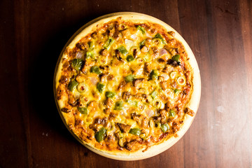 Pan Pizza take from top view with dark brown wood