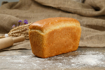 Wheat bread on a wooden background with spikelet of wheat