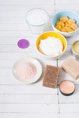 bath salts, beeswax , makeup base, powder compact, soaps and cosmetic creams on white wooden background