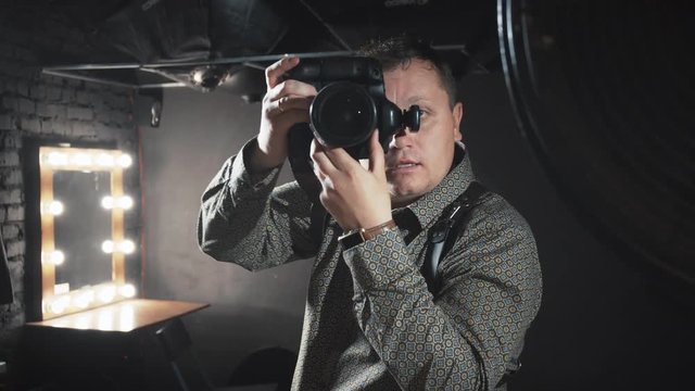 Photographer takes pictures in a photo studio.