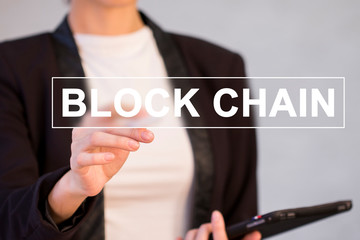 Businessman presses button blockchain on virtual digital electronic user interface.