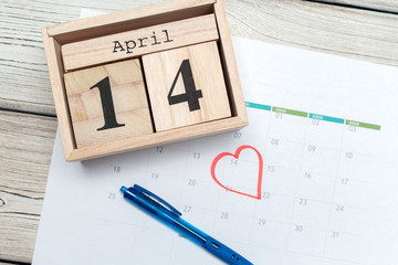 April 14th. Day 14 of april month, calendar on table with blue  background. Spring time