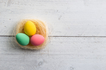 Colored easter eggs on white wooden