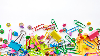 Colorful stationary, back to school, office, business and education concept. School and office supplies paper clips, pins on white background. Top view, close up