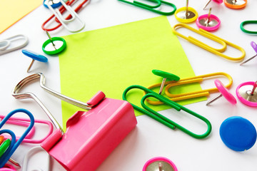 Colorful stationary, back to school, office, business and education concept. School and office supplies paper clips, pins, notes, stickers on white background, flatlay. Mock up. Top view, close up
