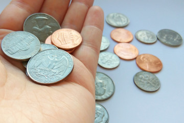 Close up American quarter, dime and penny coins in hand on two dollars usa background